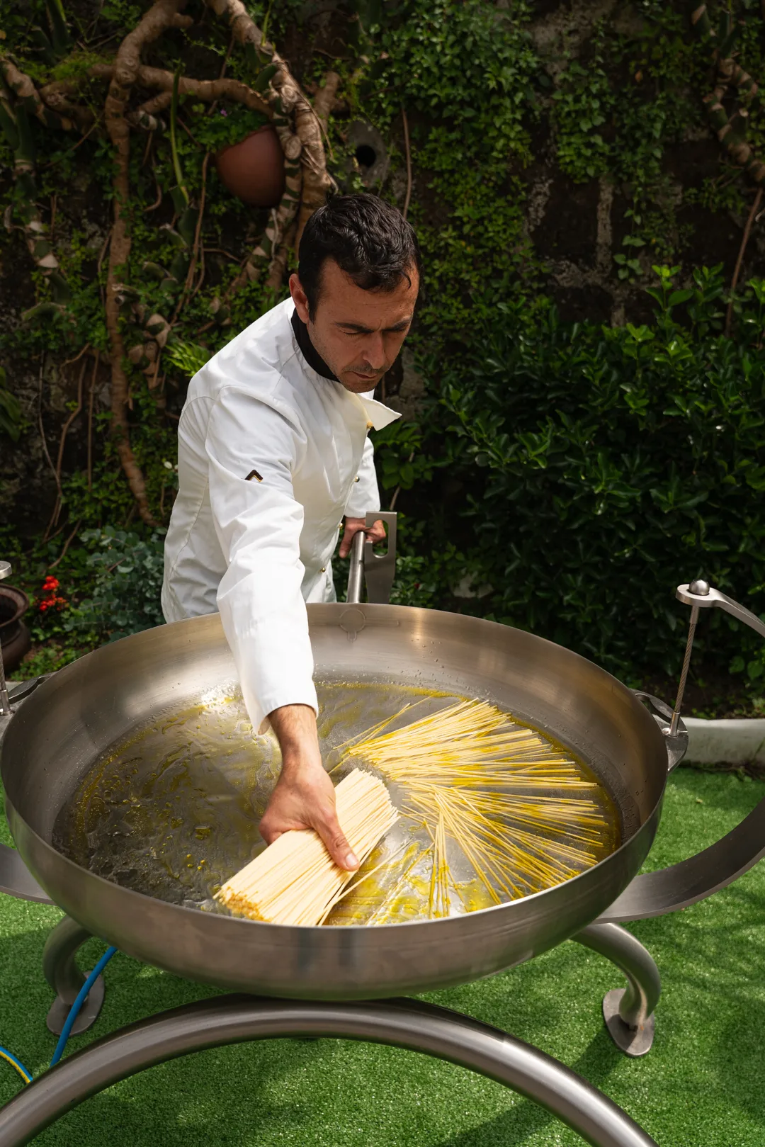 Lo chef cuoce gli spaghetti in una maxi pentola per il catering