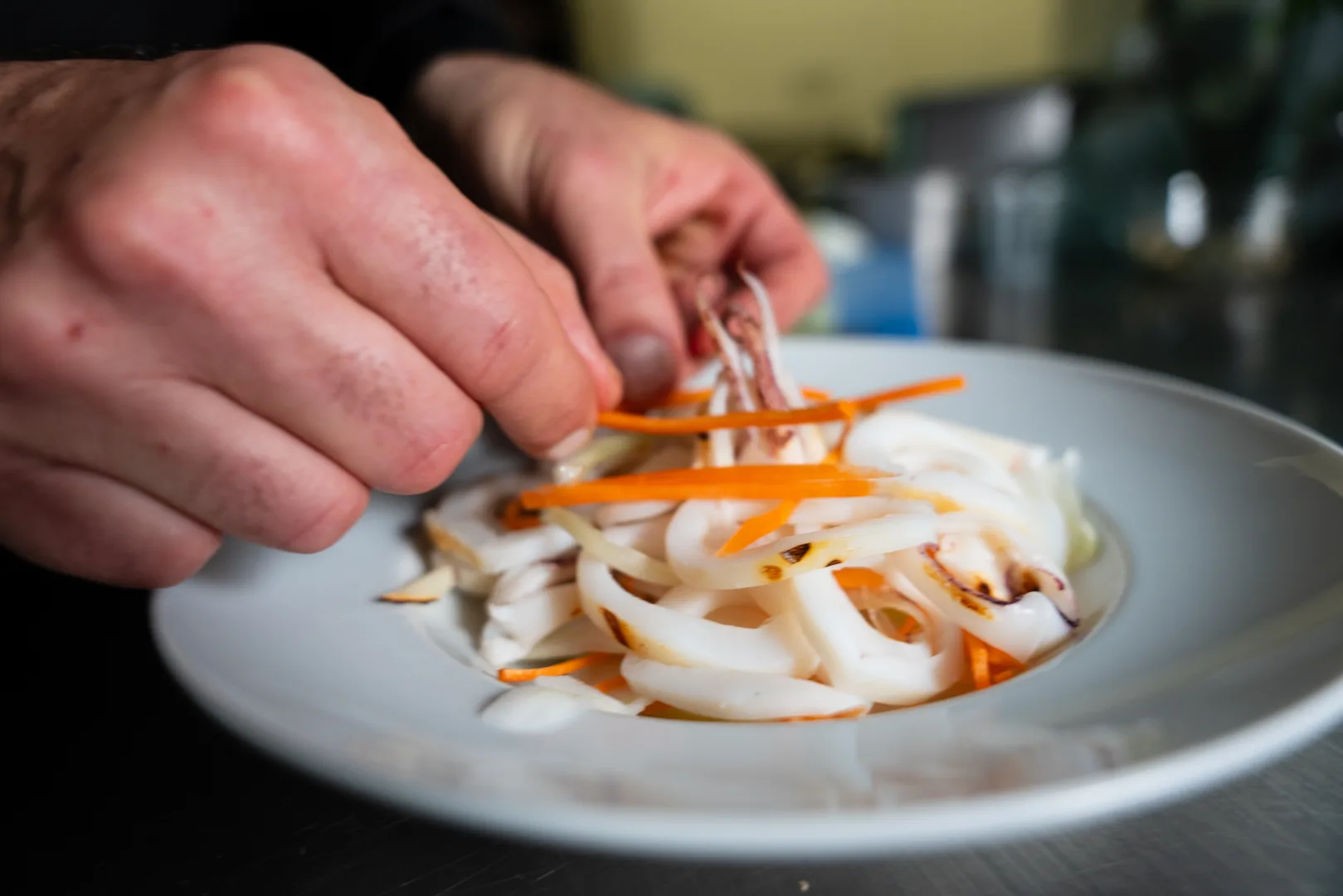 Chef impiatta un antipasto di calamari alla griglia