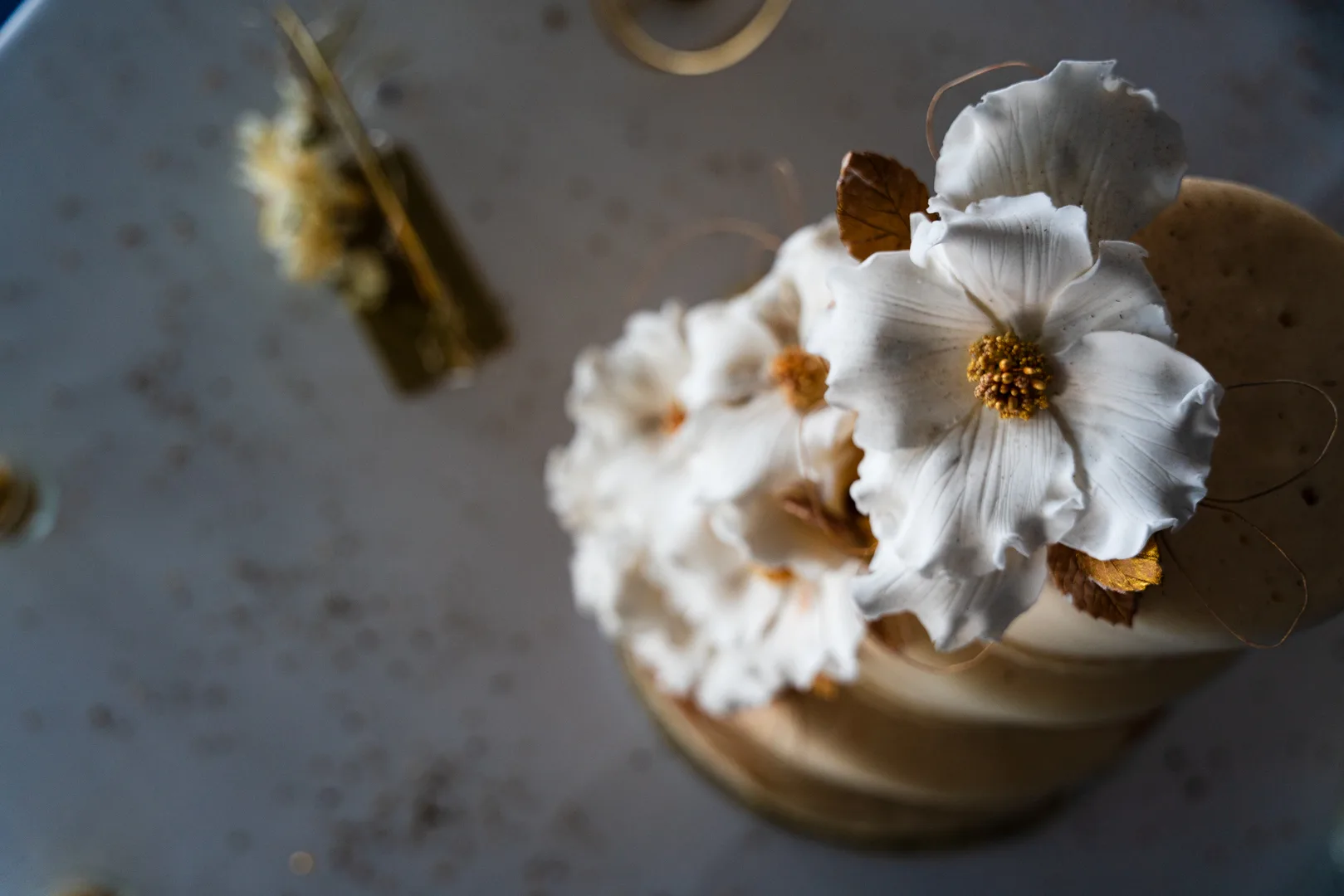 Dettaglio floreale su una torta scenografica dorata
