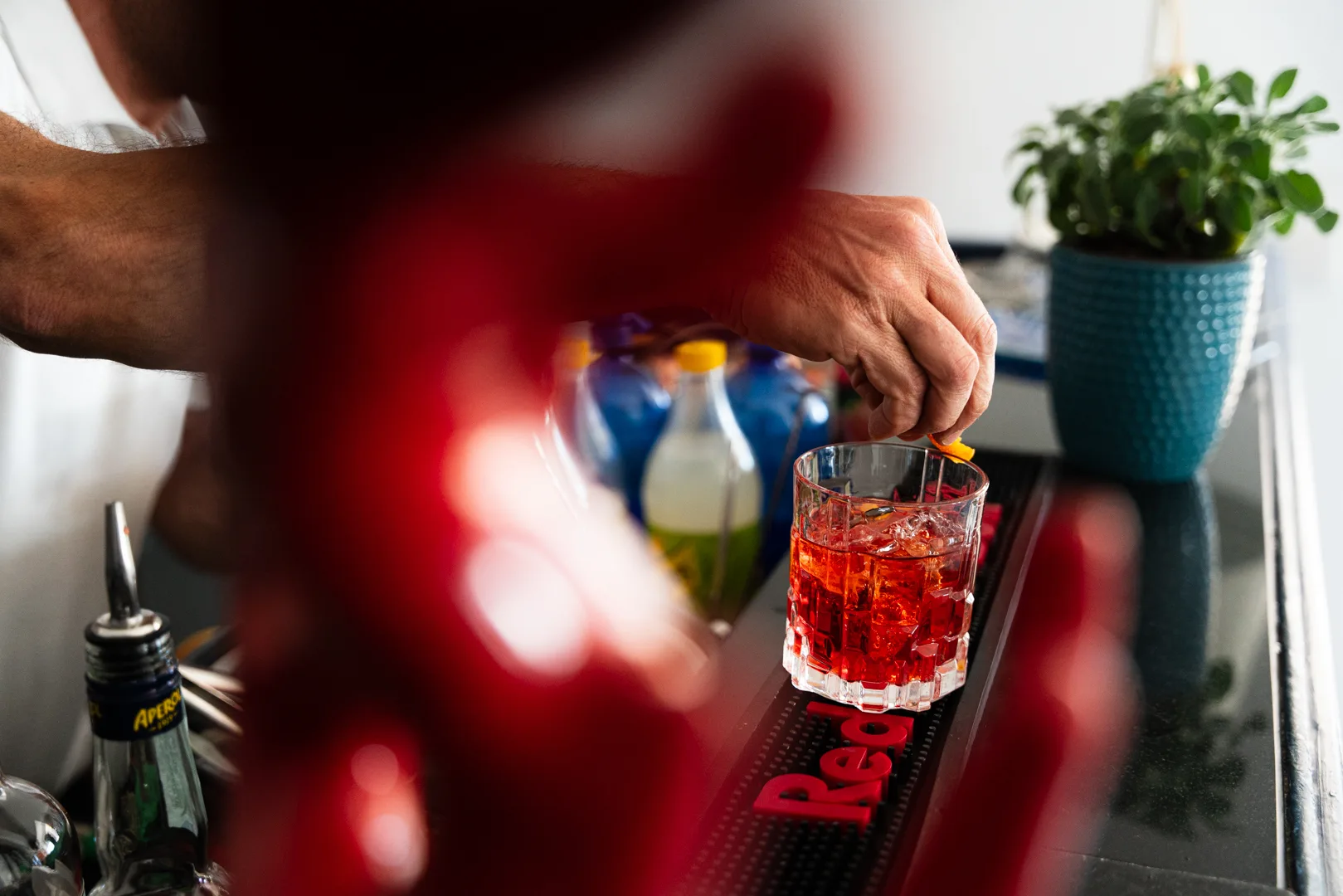 Negroni servito al bancone con guarnizione d'arancia