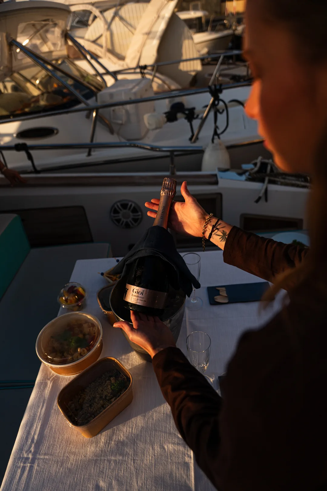 Bottiglia stappata in barca per un aperitivo al tramonto