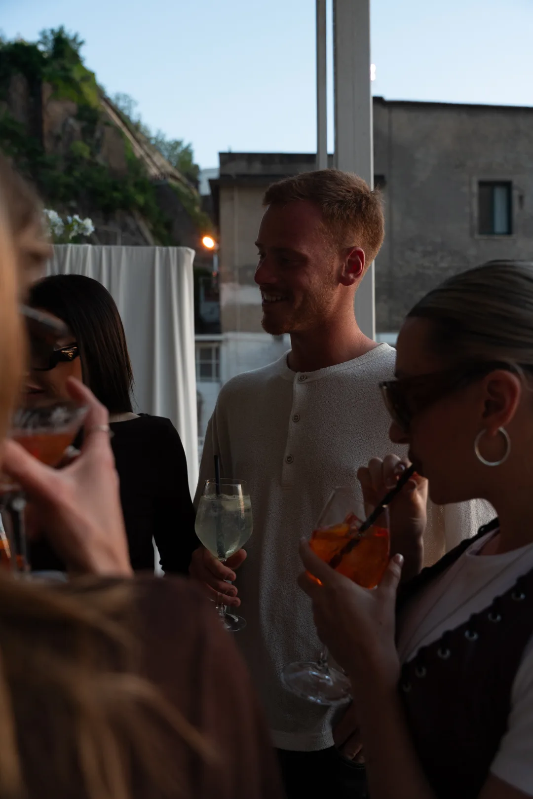 Gruppo di amici sorseggia un aperitivo in terrazza